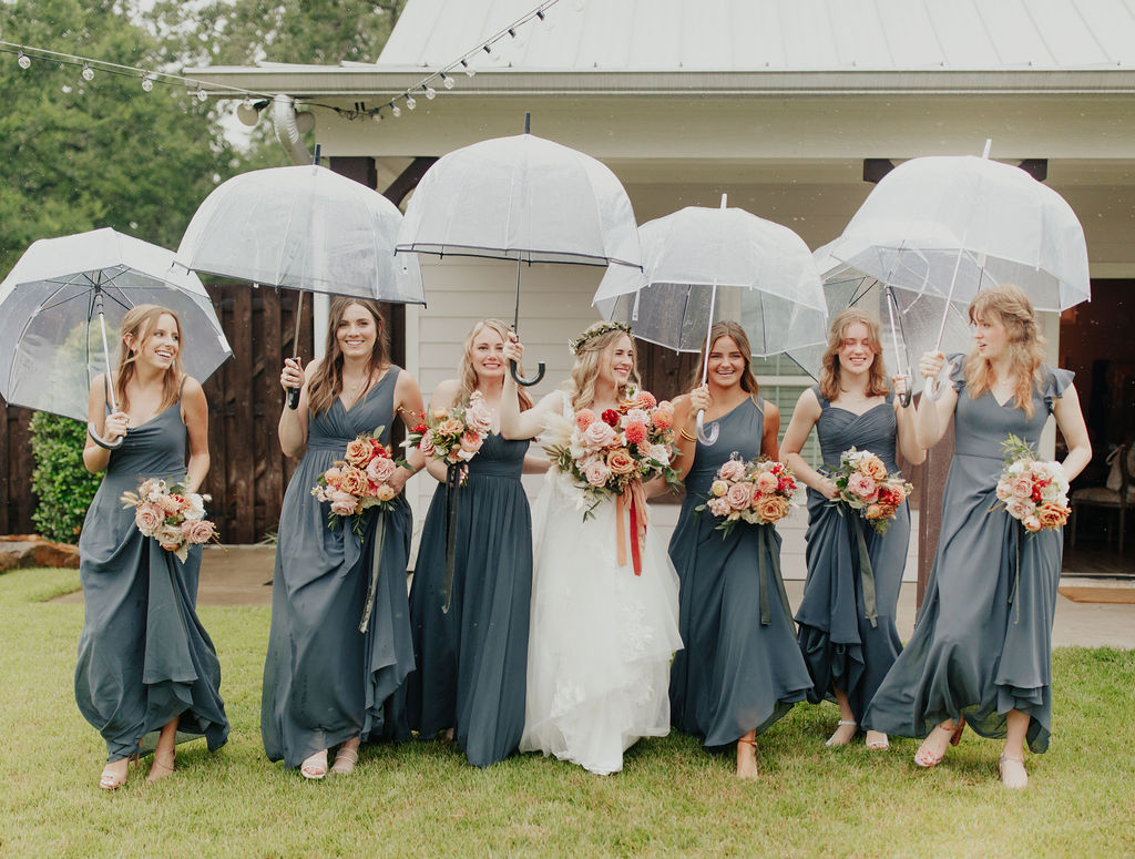 clear umbrellas with bridesmaids at wedding in college station